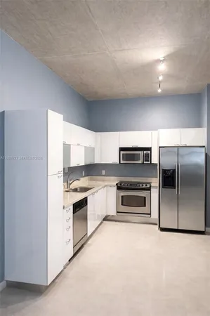 a kitchen with stainless steel appliances a stove a microwave and a refrigerator