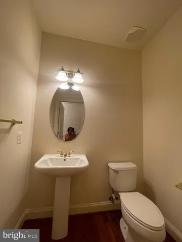 a bathroom with a toilet a sink and mirror