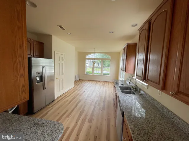 a view of a refrigerator in kitchen and wooden floor