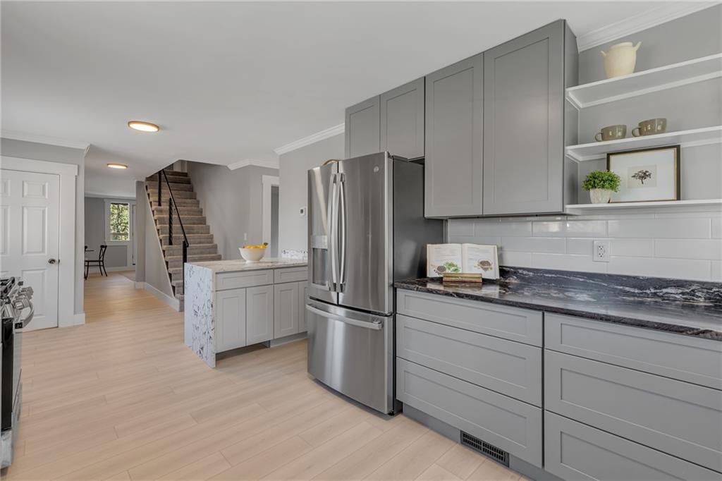 601 Center Avenue Pittsburgh, PA 15202 - Photo 12 of 48 a kitchen with granite countertop a refrigerator and a stove top oven