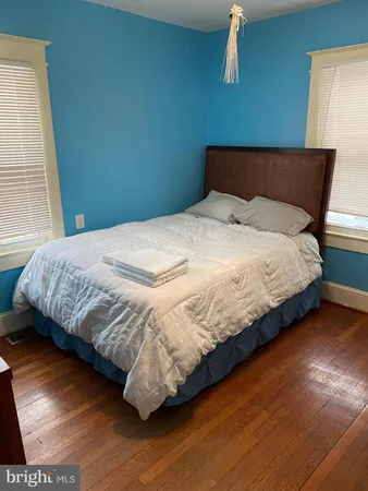 a bedroom with a bed and wooden floor