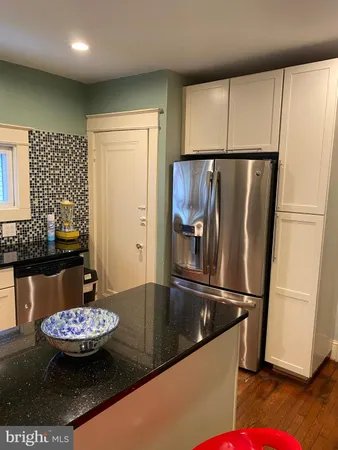 a view of a refrigerator in kitchen and dining area with chandelier