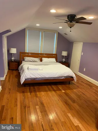 a large bedroom with a bed and wooden floor