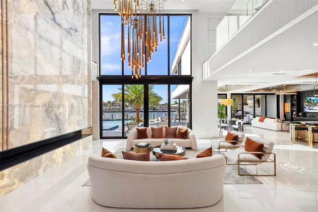 a living room with patio furniture and floor to ceiling windows