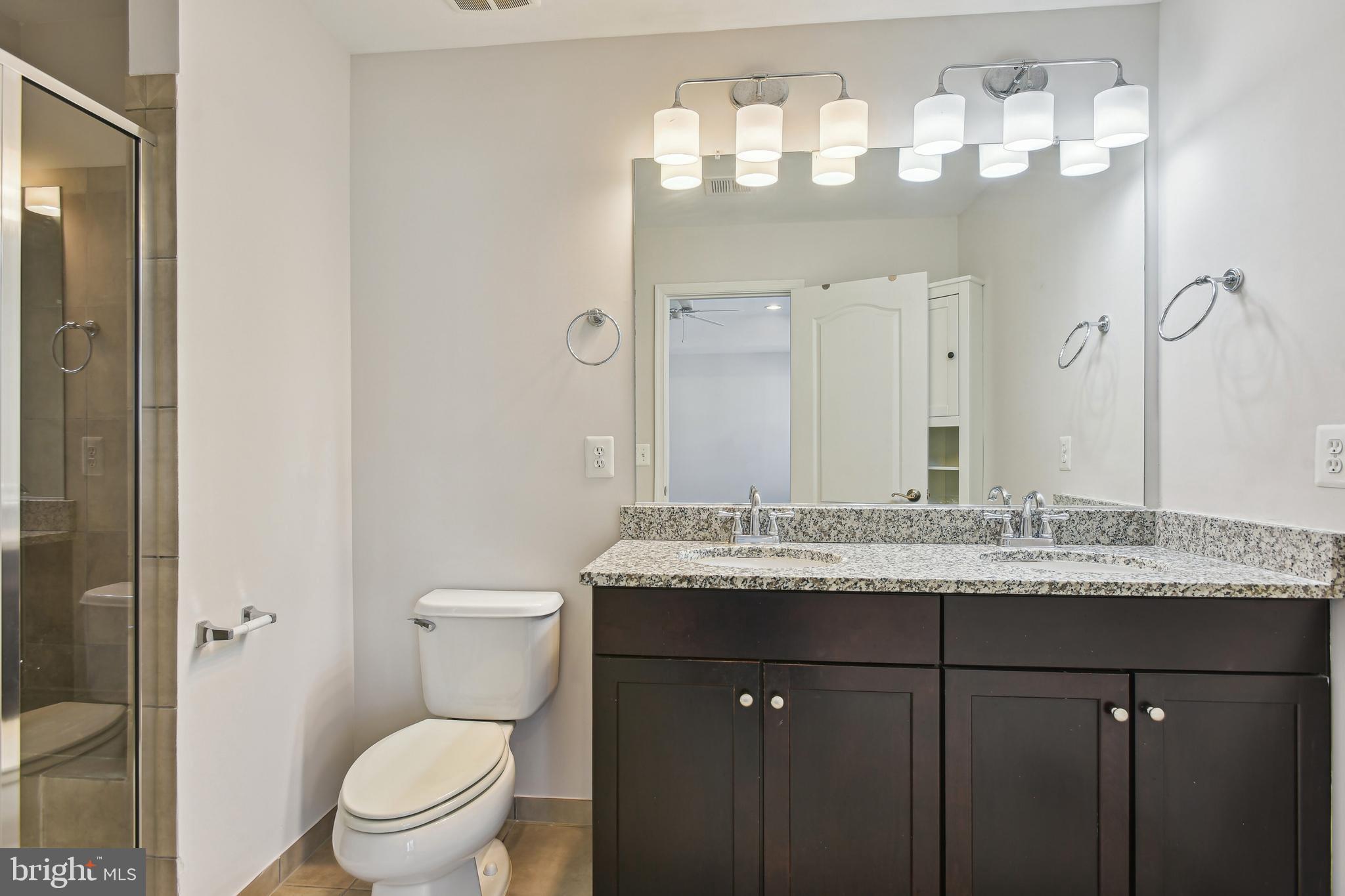 22652 Gray Falcon Square Ashburn, VA 20148 - Photo 16 of 24 a bathroom with a granite countertop sink a toilet and a mirror