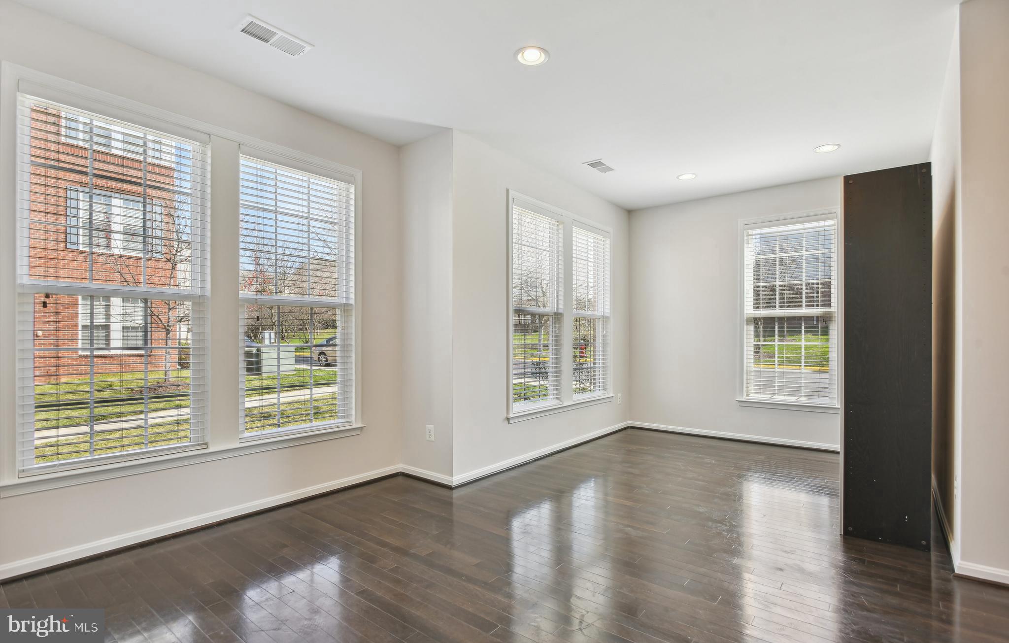 22652 Gray Falcon Square Ashburn, VA 20148 - Photo 21 of 24 a view of an empty room with wooden floor and a window