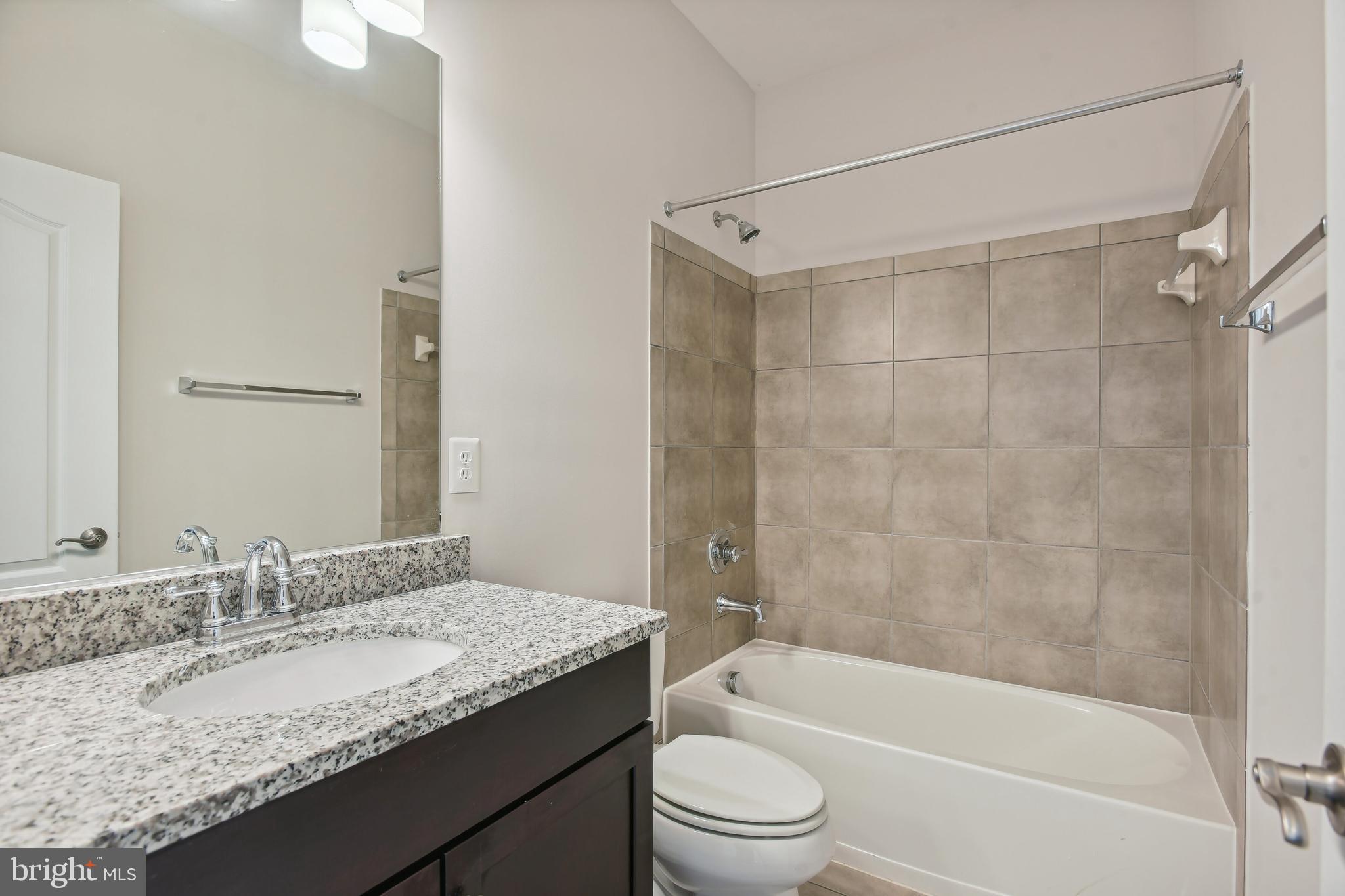22652 Gray Falcon Square Ashburn, VA 20148 - Photo 22 of 24 a bathroom with a granite countertop sink a toilet and shower