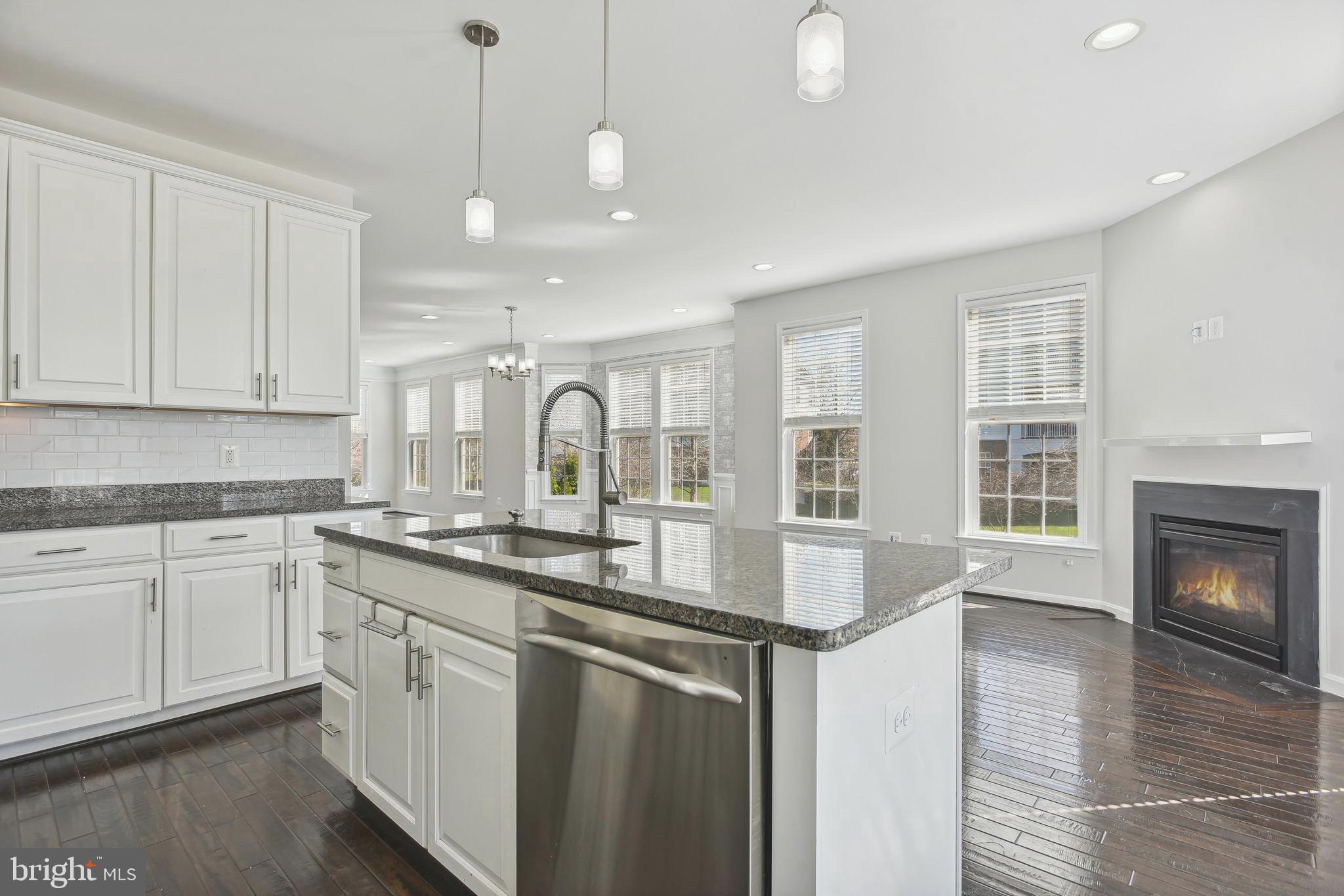 22652 Gray Falcon Square Ashburn, VA 20148 - Photo 7 of 24 a kitchen with stainless steel appliances granite countertop a sink a stove and a wooden floors