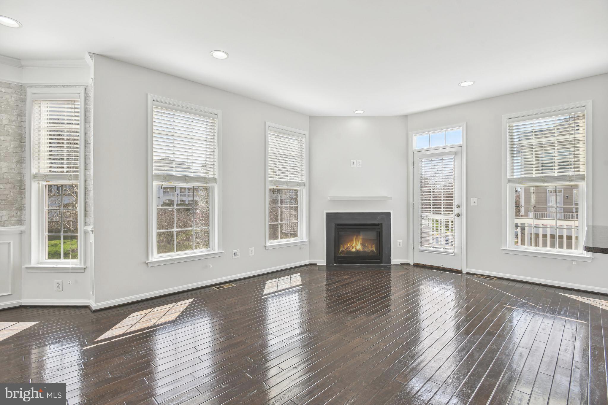 22652 Gray Falcon Square Ashburn, VA 20148 - Photo 8 of 24 a view of an empty room with wooden floor and a window