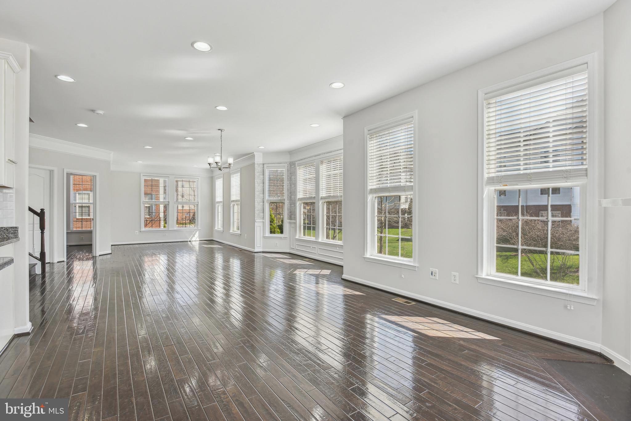 22652 Gray Falcon Square Ashburn, VA 20148 - Photo 9 of 24 a view of an empty room with wooden floor and a window