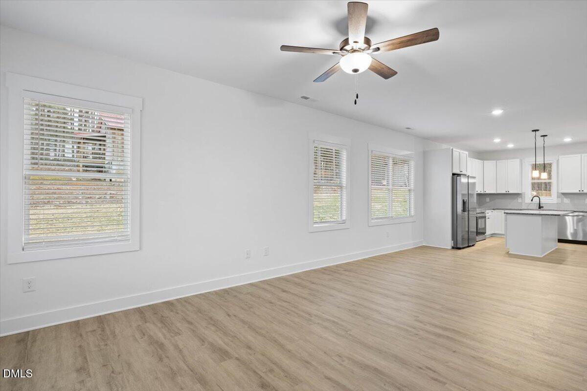 929 Jasmine Road Fuquay-Varina, NC 27526 - Photo 10 of 27 a view of an empty room with window and wooden floor