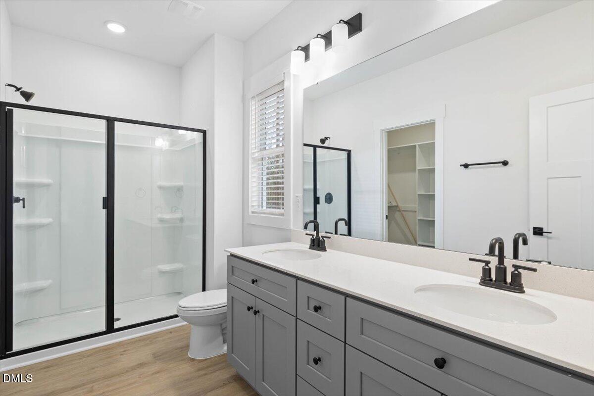929 Jasmine Road Fuquay-Varina, NC 27526 - Photo 16 of 27 a bathroom with a double vanity sink toilet mirror and shower