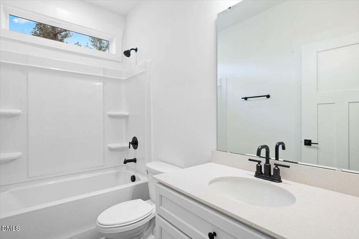 929 Jasmine Road Fuquay-Varina, NC 27526 - Photo 19 of 27 a bathroom with a bathtub shower sink vanity mirror and toilet