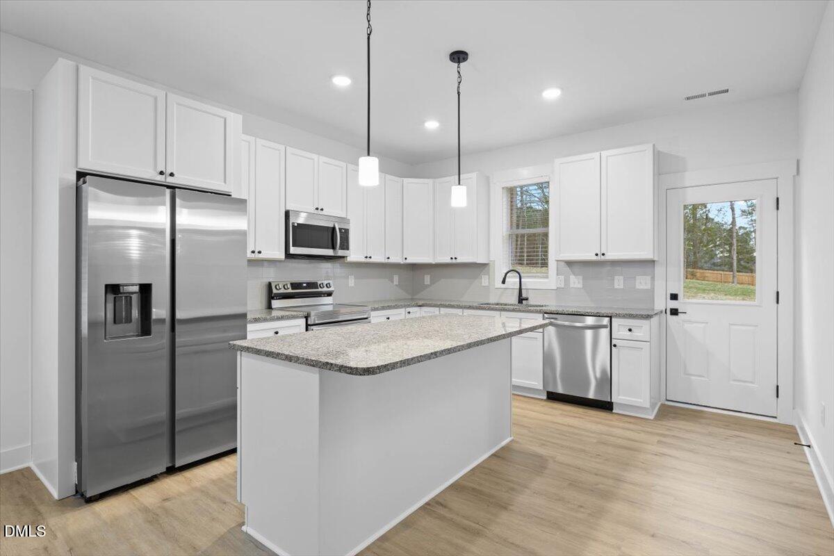 929 Jasmine Road Fuquay-Varina, NC 27526 - Photo 3 of 27 a kitchen with stainless steel appliances granite countertop a refrigerator a sink and a stove