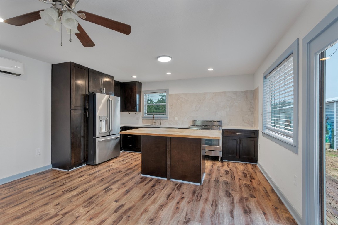 1100 High Road San Marcos, TX 78666 - Photo 3 of 36 a kitchen with stainless steel appliances a refrigerator and a wooden floor