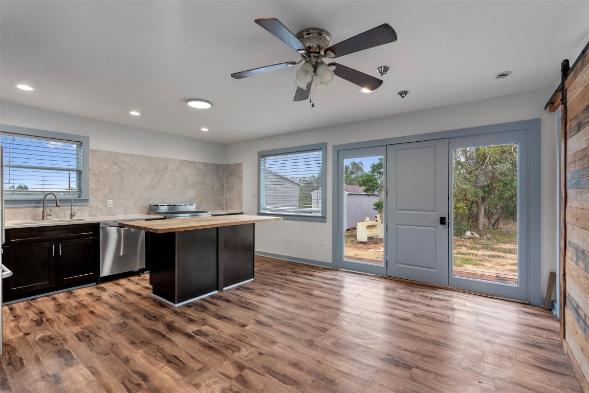 1100 High Road San Marcos, TX 78666 - Photo 7 of 36 a large kitchen with stainless steel appliances kitchen island granite countertop a refrigerator a sink dishwasher a stove and a dining table with wooden floor