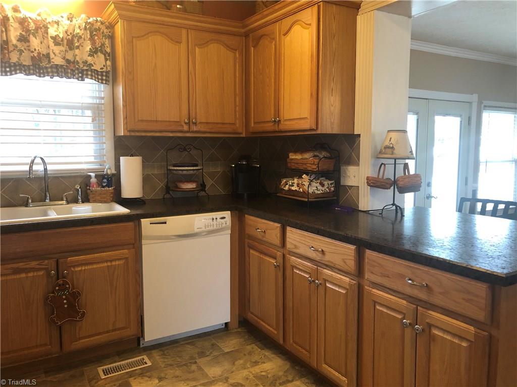 156 Mills Road Mount Airy, NC 27030 - Photo 5 of 29 Kitchen has beautiful custom cabinets, pull out spice rack, refrigerator, dishwasher.