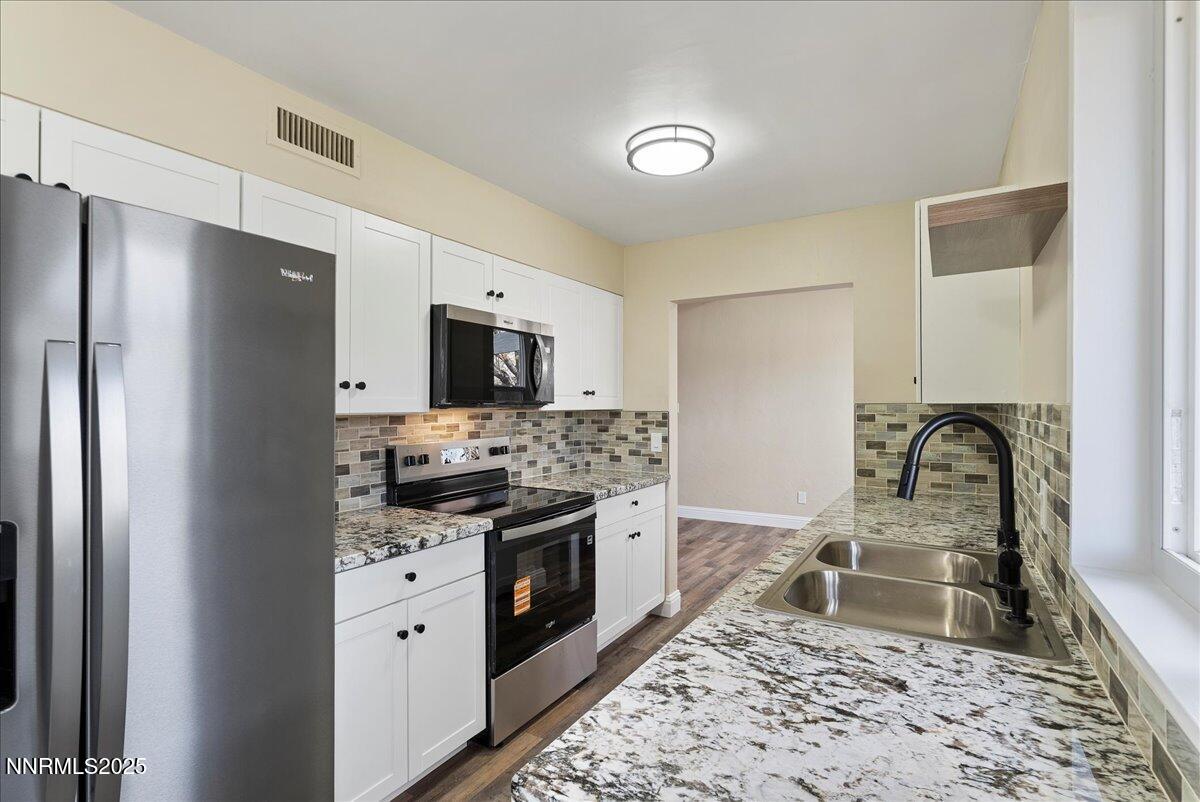 11642 Green Mountain Street Reno, NV 89506 - Photo 8 of 20 a kitchen with stainless steel appliances granite countertop a stove top oven a sink and a refrigerator