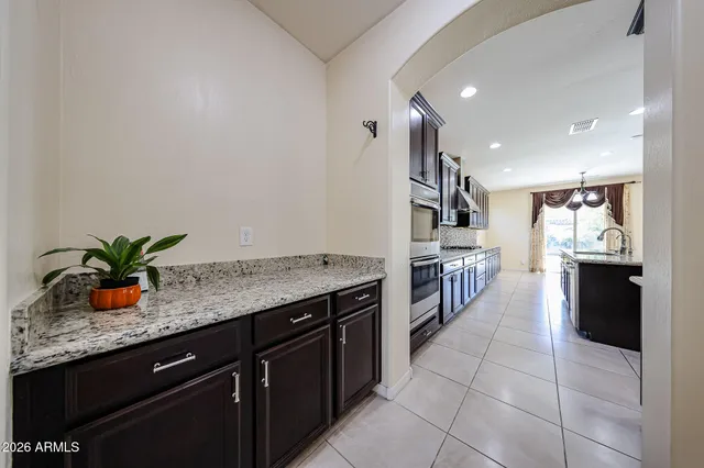 a large kitchen with granite countertop a stove refrigerator and cabinets