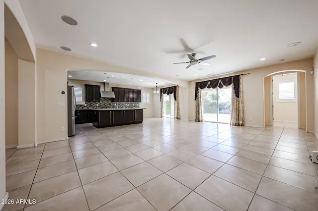 a large kitchen with stainless steel appliances granite countertop a large counter top a stove a chimney a sink and a refrigerator