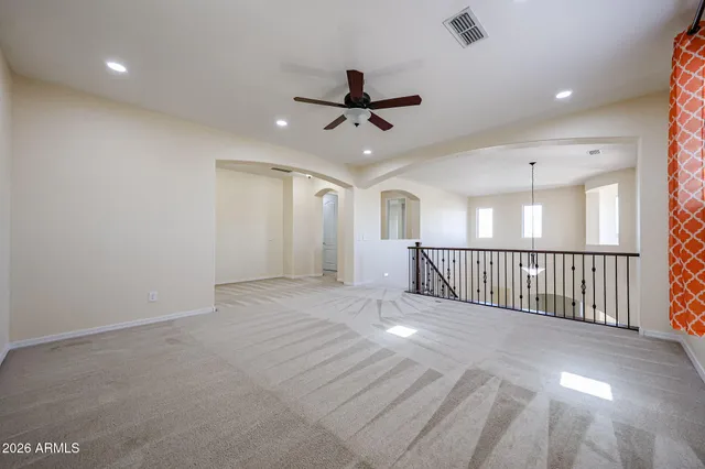 an empty room with windows and fan