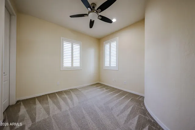an empty room and chandelier fan