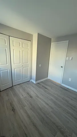 an empty room with wooden floor and sliding door