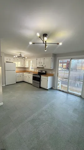 a large white kitchen with a large window and stainless steel appliances
