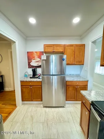 a kitchen with stainless steel appliances granite countertop a refrigerator a stove and a sink