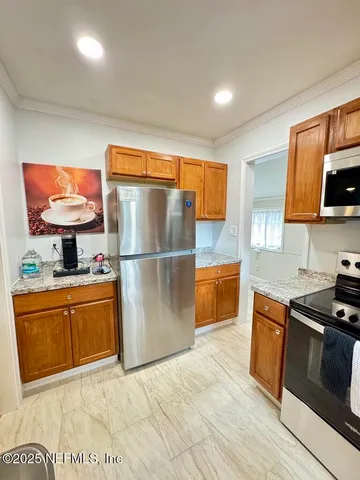 a kitchen with stainless steel appliances granite countertop a refrigerator a stove top oven a sink and dishwasher