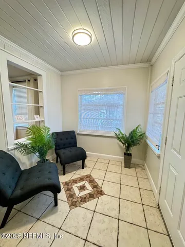 a living room with a couch and a potted plant on a table
