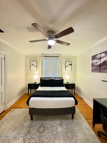 a bedroom with a bed and wooden floor