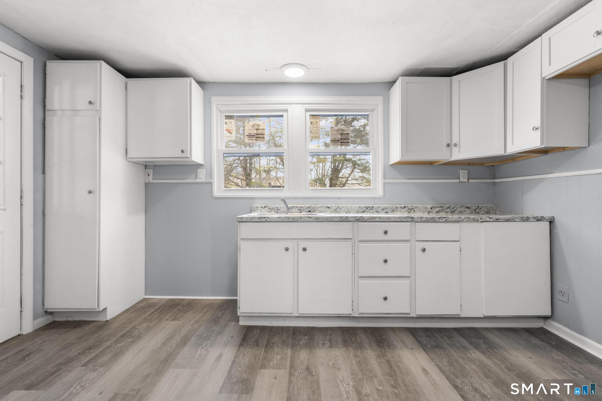 68 Thomaston Road Litchfield, CT 06791 - Photo 5 of 18 a kitchen with granite countertop white cabinets and wooden floor