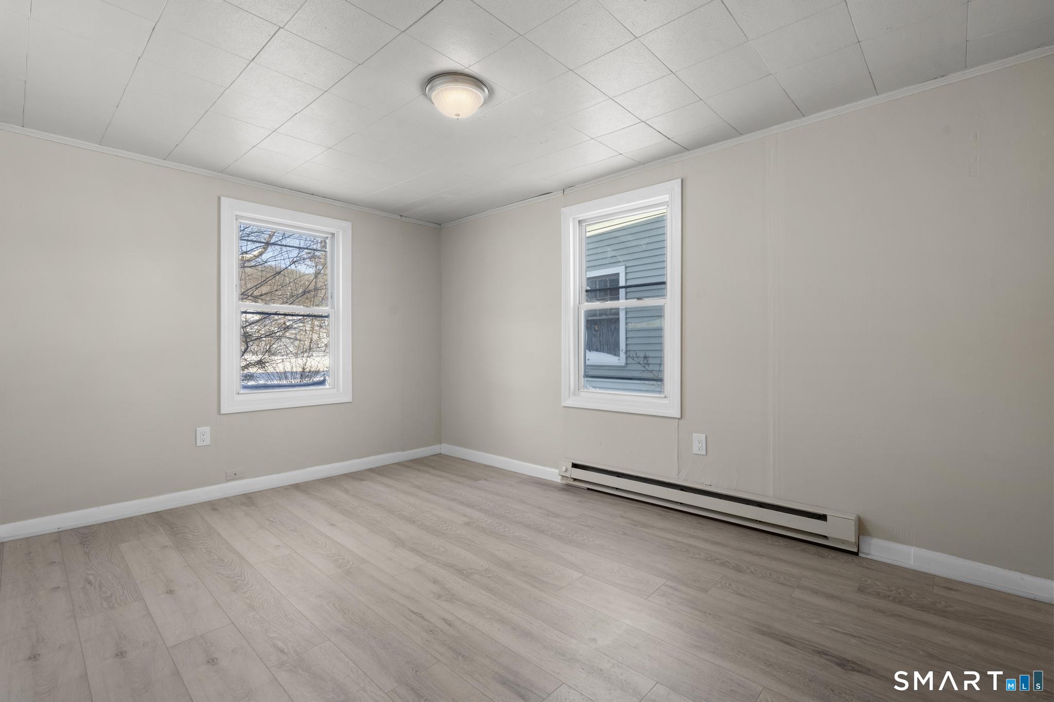 68 Thomaston Road Litchfield, CT 06791 - Photo 6 of 18 an empty room with wooden floor and windows