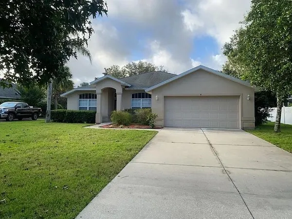 a front view of a house with a yard and trees