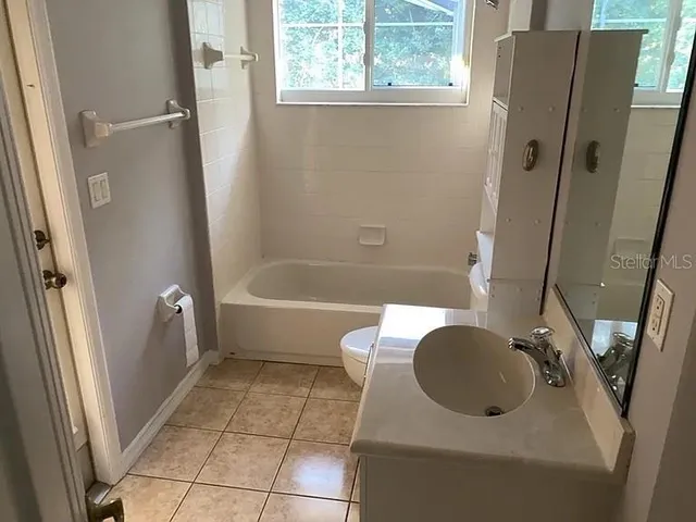 a bathroom with a tub a sink and a mirror
