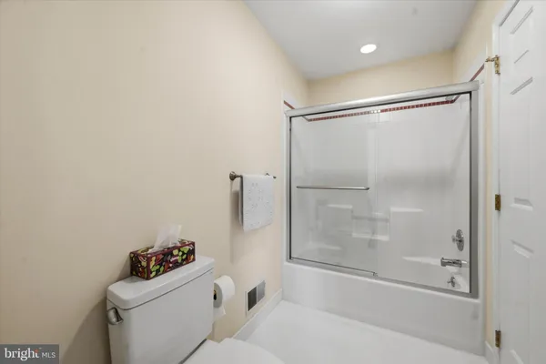 a bathroom with a bathtub mirror and toilet