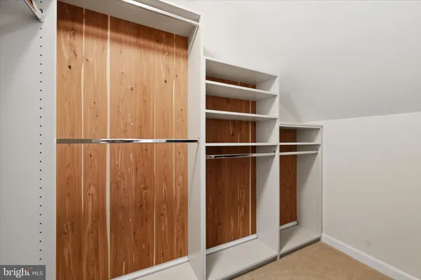 a view of walk in closet with empty racks