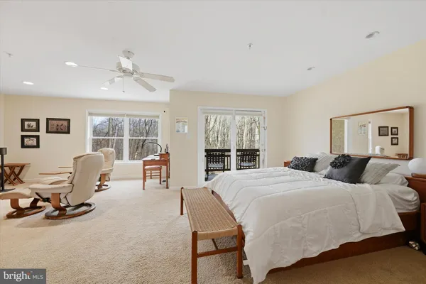 a bedroom with a bed a large window and chair