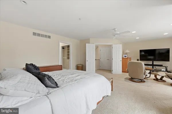 a bedroom with a bed and large windows