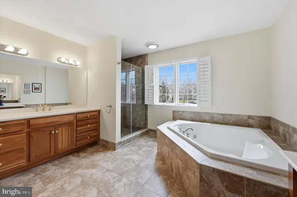 a spacious bathroom with a tub sink and mirror