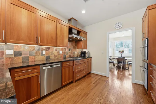 a kitchen with granite countertop wooden floors and white cabinets