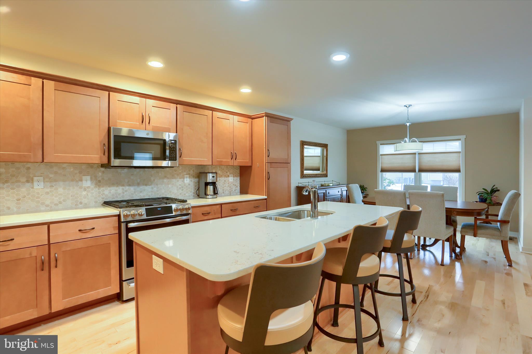 6238 Overview Lane Harrisburg, PA 17111 - Photo 11 of 34 a kitchen with stainless steel appliances granite countertop a stove a sink a microwave a dining table and chairs