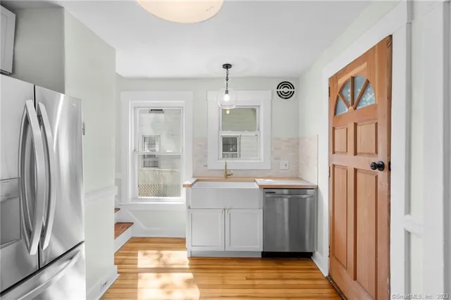 a living room with stainless steel appliances granite countertop a refrigerator and a stove