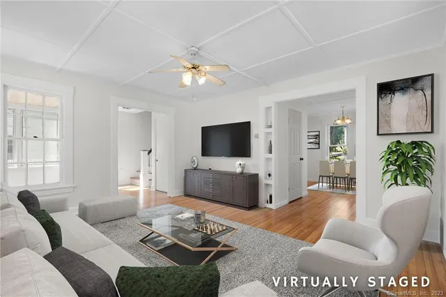 a living room with furniture a flat screen tv and a window