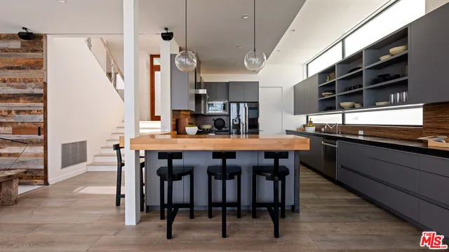 a kitchen with a table chairs and wooden floor