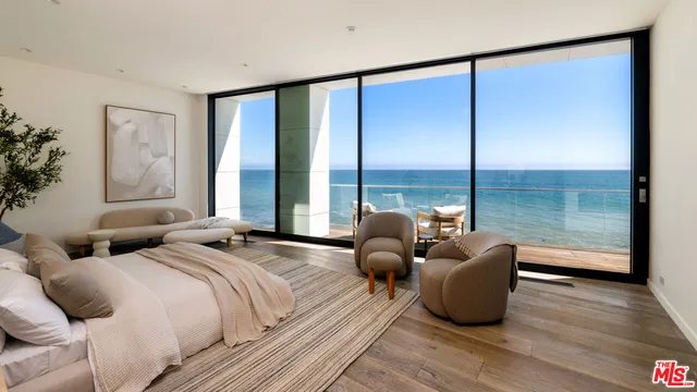 a spacious bedroom with two beds and glass window