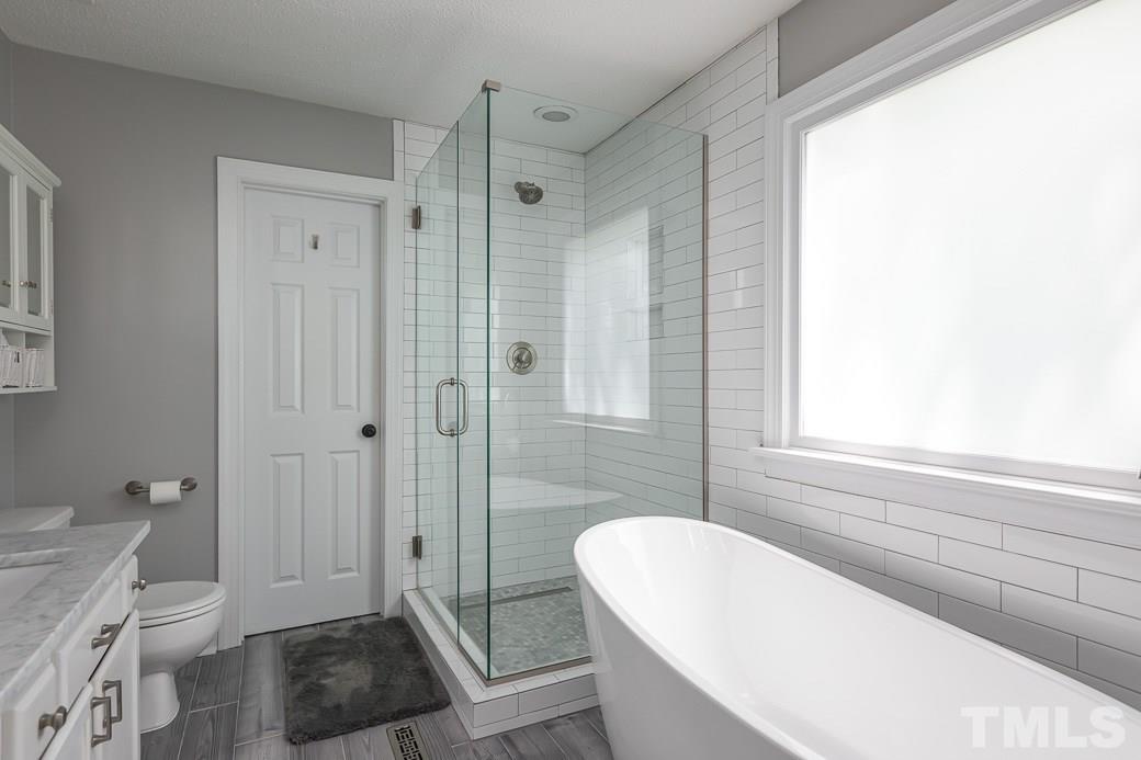 5420 Bakers Mill Road Durham, NC 27707 - Photo 11 of 20 Upgraded bath has shower with glass and tile surround. Modern tub.