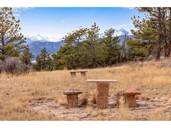 a small barn with a large window and potted plants
