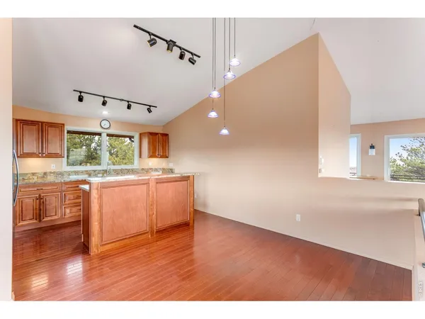 a kitchen with stainless steel appliances granite countertop a sink window and wooden floor